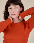 Front close up of Long Sleeve Baby Tee in Chili Red on Alex
