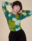 Alex is 5’8” and wearing P Long Sleeve Baby Tee in Green Magic Waters