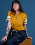 Sydney is wearing Painted Burly Tee in Mustard Yellow