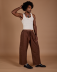 Jerrod is 6’3” and wearing M Drop Pocket Cargo Pants in Fudgesicle Brown paired with a Tank Top in vintage tee white