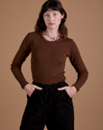 Alex is 5’8” and wearing XP Gingham Long Sleeve Baby Tee in Fudgesicle Brown