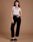 Alex is 5'8" and wearing XXS Organic Work Pants in Basic Black paired with a vintage tee white Cropped Tank