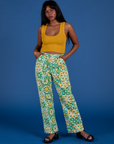 Kandia is 5’3” and wearing XS Work Pants in Spring Quilt Print paired with a mustard yellow Cropped Tank