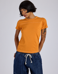 Kira is 5’10” and wearing P Jr. Varsity Tee in Creamsicle Orange
