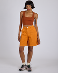 Kira is 5’10” and wearing XS Longline Work Shorts in Creamsicle Orange paired with a burnt terracotta Cropped Tank