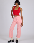 Kira is 5’10” and wearing XS Work Pants in Baby Pink paired with mustang red Cropped Tank