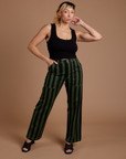 Tiara is 5’4” and wearing S Black Stripe Work Pants in Evergreen paired with a black Cropped Tank