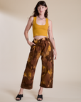 Alex is 5’8” and wearing XXS Magic Waters Drop Pocket Pants in Honey Brown paired with mustard yellow Cropped Tank
