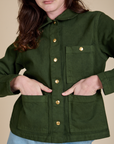 Alex has both hands in the front pockets of Denim Work Jacket in Evergreen