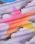 Airbrush Star Vintage Tee fabric detail close up. Airbrushed grey and white clouds with a gradient star in pink, orange and yellow.