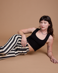 Alex is wearing Black Stripe Work Pants in White and black Cropped Tank