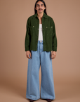 Anthony is wearing Cropped Corduroy Overshirt in Evergreen and light wash Indigo Wide Leg Trousers