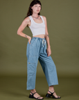 Angled front view of Denim Drop Pocket Pants in Light Wash and vintage tee white Cropped Tank on Alex