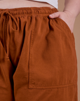 Close up of Ashley's hand in the front pocket of Drop Pocket Cargo Pants in Burnt Terracotta