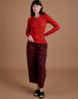 Alex is wearing Gingham Long Sleeve Baby Tee in Mustang Red paired with red wine Drop Pocket Cargo Pants