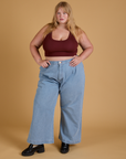 Juliet is wearing Mini Tank in Red Wine and light wash Indigo Wide Leg Trousers