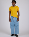 Isaac is wearing Jr. Varsity Tee in Sunshine Yellow and light wash Denim Drop Pocket Pants
