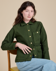 Alex is wearing a buttoned up Denim Work Jacket in Evergreen