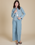 Alex is wearing Indigo Denim Work Jacket in Light Wash paired with light wash Indigo Wide Leg Trousers