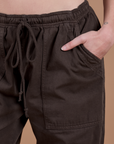 Close up of Alex's hand in the front pocket of Drop Pocket Cargo Pants in Espresso Brown