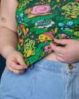 Close up of Ashley holding the hem of Cropped Tank Top in Pond Party