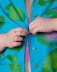 Close up of Ashley buttoning the Paintstamped Pantry Button-Up in Lilypad