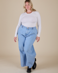 Lish is wearing Long Sleeve Baby Tee in Vintage Tee Off-White and light wash Indigo Wide Leg Trousers