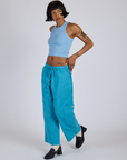 Angled front view of Drop Pocket Cargo Pants in Hawaiian Blue and baby blue Racerback Tank on Kira