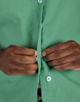 Close up of Isaac buttoning up the Pantry Button-Up in Seafoam Green