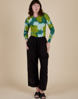 Alex is wearing Long Sleeve Baby Tee in Green Magic Waters and black Drop Pocket Cargo Pants