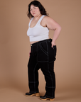 Side view of Carpenter Jeans in Black and Cropped Tank in Vintage Tee White on Ashley