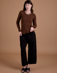 Alex is wearing Gingham Long Sleeve Baby Tee in Fudgesicle Brown and black Drop Pocket Cargo Pants