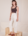 Angled view of Heavyweight Trousers in Vintage Tee Off-White and espresso brown Cropped Tank Top worn by Alex.