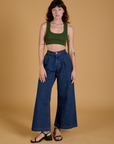 Alex is wearing Mini Tank in Evergreen and dark wash Indigo Wide Leg Trousers