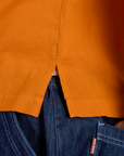 Close up of Pantry Button-Up in Creamsicle Orange side vent