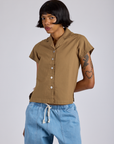 Kira is wearing a buttoned up Pantry Button-Up in Desert Brown