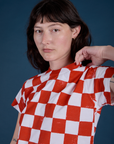 Angled front view close up of Checker Organic Tee in Red on Alex