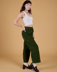 Side view of Corduroy Drop Pocket Cargo Pants in Evergreen and Cropped Tank in Vintage Tee White on Alex
