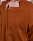 Close up of Ashley's hand in the back pocket of Drop Pocket Cargo Pants in Burnt Terracotta