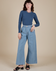 Alex is wearing Long Sleeve Baby Tee in French Blue and light wash Indigo Wide Leg Trousers