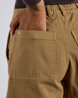 Close up of Kira's hand in the back pocket of Longline Work Shorts in Desert Brown