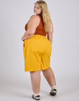 Longline Work Shorts in Sunshine Yellow angled back view on Juliet