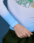Sleeve and bottom of shirt close up of Floral Long Sleeve Baby Tee in Baby Blue on Madeline