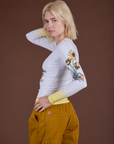 Side view of Floral Long Sleeve Baby Tee in Yellow with focus on the screen print sleeve