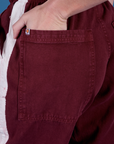 Close up of Alex's hand in the back pocket of Painted Drop Pocket Cargo Pants in Red Wine