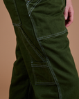 Carpenter Jeans in Evergreen pant leg side view close up on Quinn