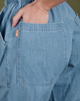 Close up of Alex's hand in the back pocket of Denim Drop Pocket Pants in Light Wash