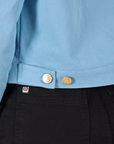 Close up of custom brass buttons on Mechanic Jacket in Baby Blue