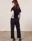 Petite Short Sleeve Jumpsuit in Basic Black back view on Hana with her hand in the back pocket.