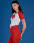 Side view of Produce Raglan Tee in Tomato on Alex